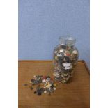 A glass jar containing buttons