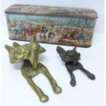 Two brass fox door knockers and a tin with hunting scenes