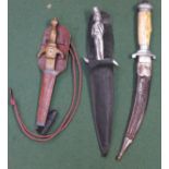 Three daggers; one figural handle, one curved blade and one small brass