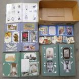 Three albums of Victorian and Edwardian postcards including photographic, song cards, a small tin of