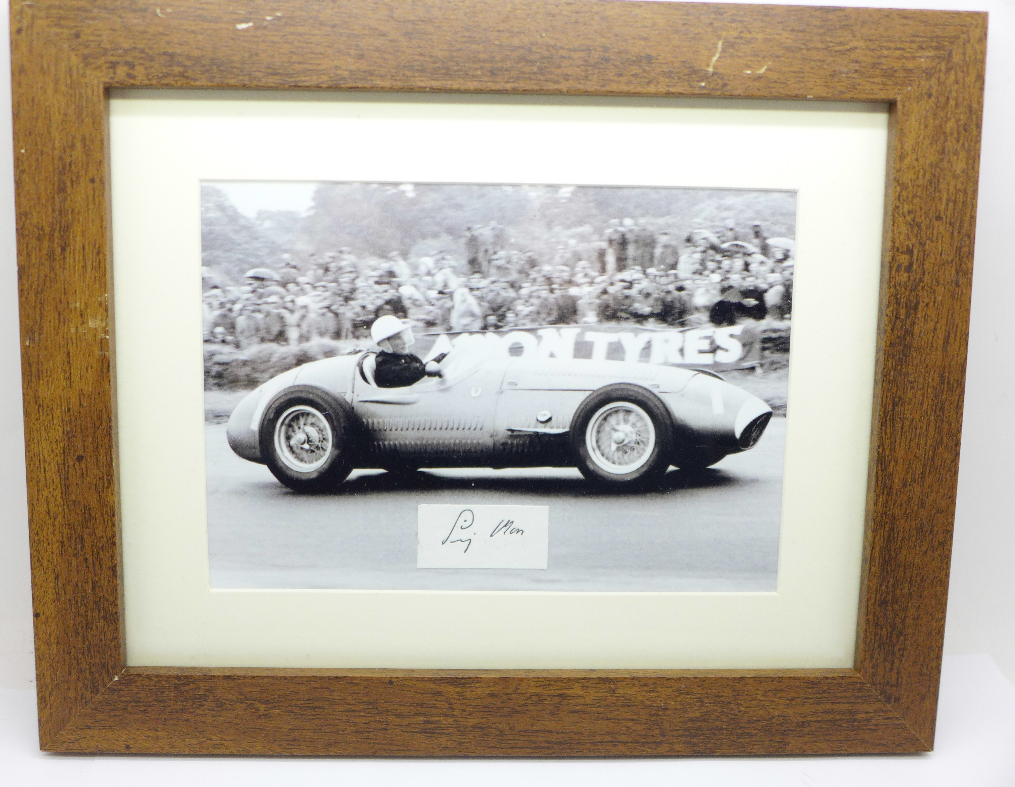 A framed photograph and autograph of Sir Stirling Moss in a 1954 Maserati