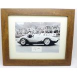 A framed photograph and autograph of Sir Stirling Moss in a 1954 Maserati
