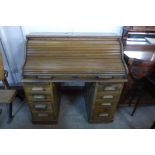 An early 20th Century oak tambour roll top desk