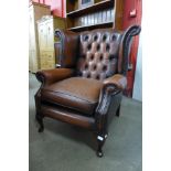 A brown leather wingback armchair