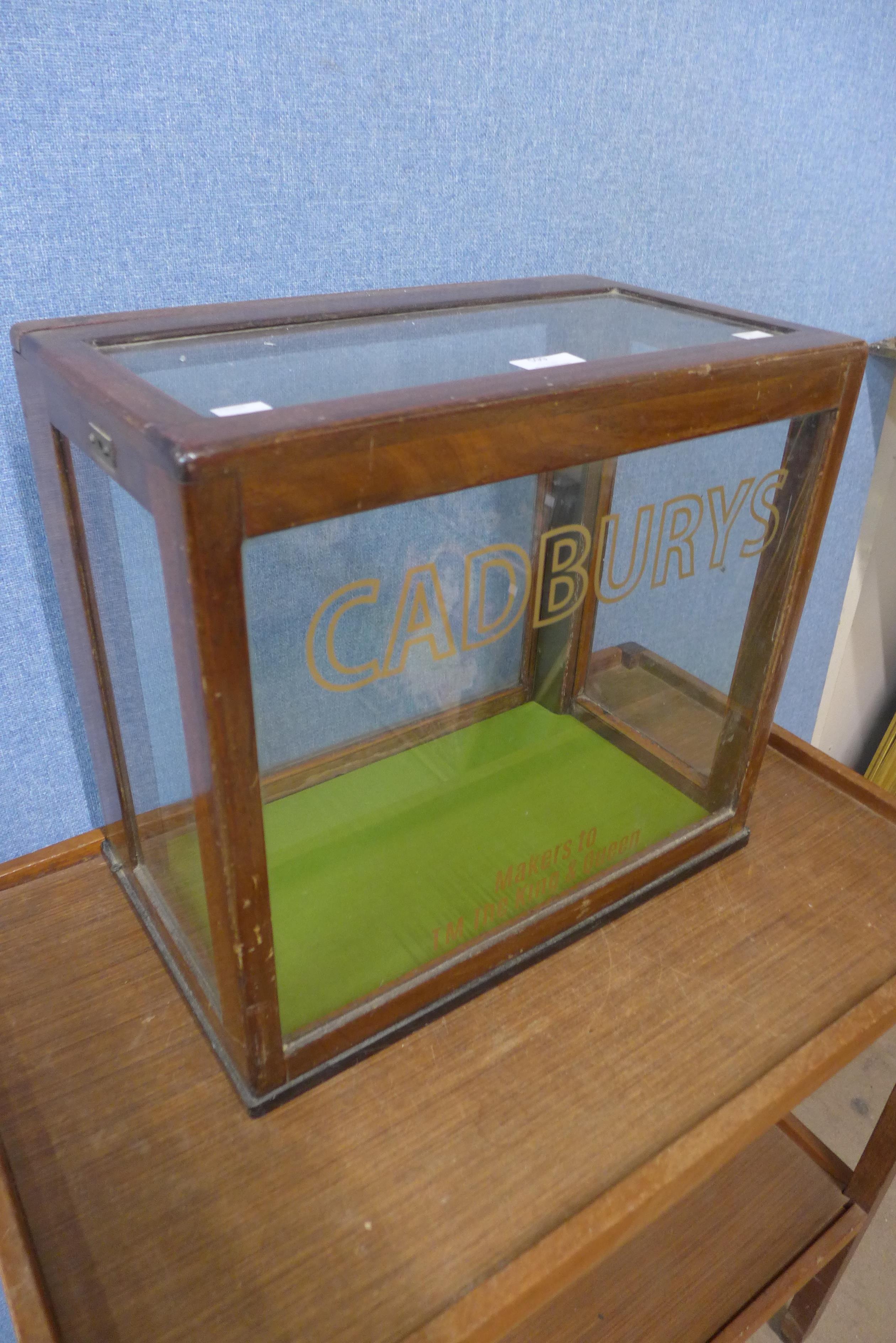 A mahogany counter top shop cabinet, bearing Cadburys inscription