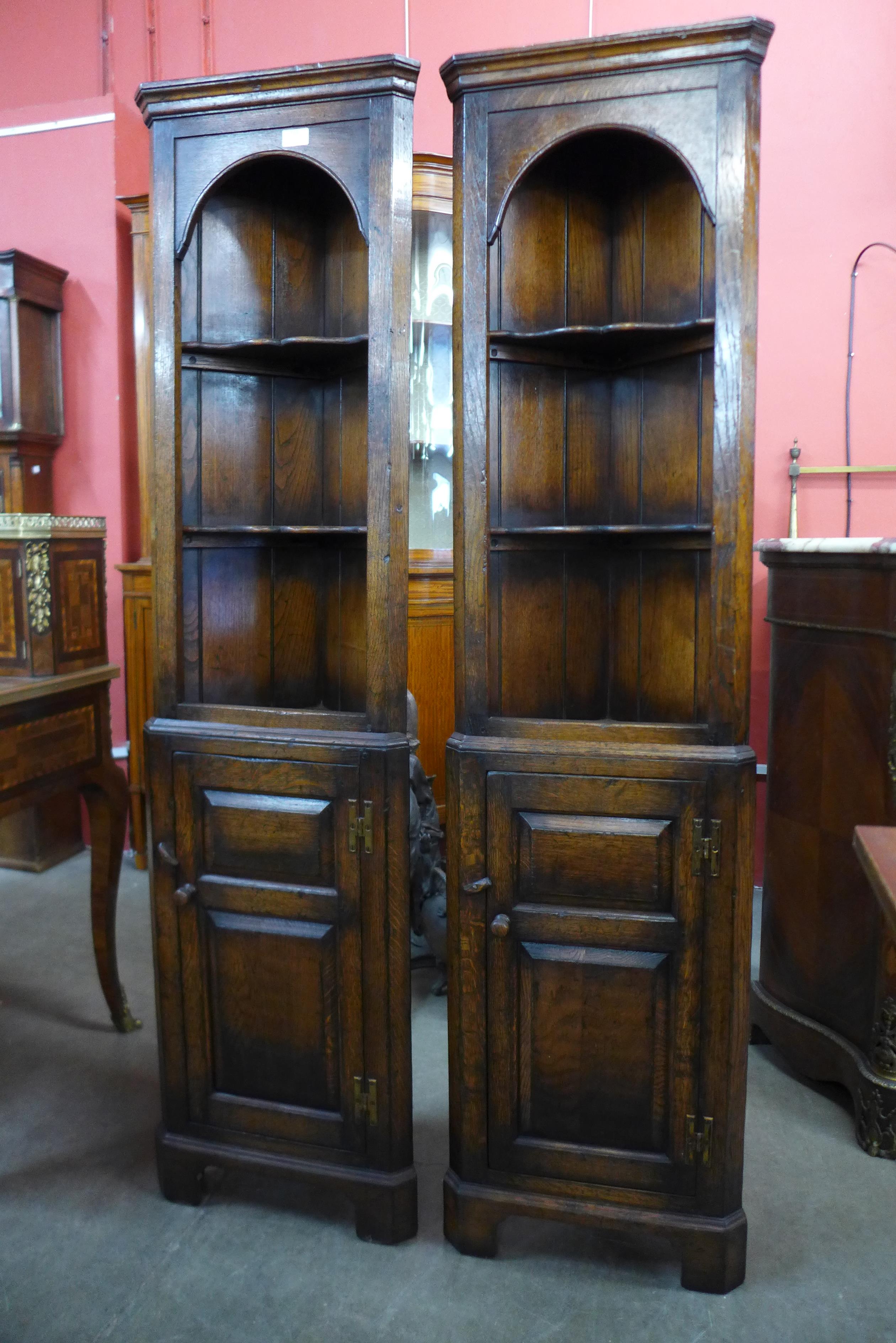 A pair of Titchmarsh & Goodwin Ipswich oak freestanding corner cabinets, 167cms h