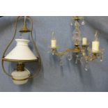 A brass hanging ceiling light and a glass three branch chandelier