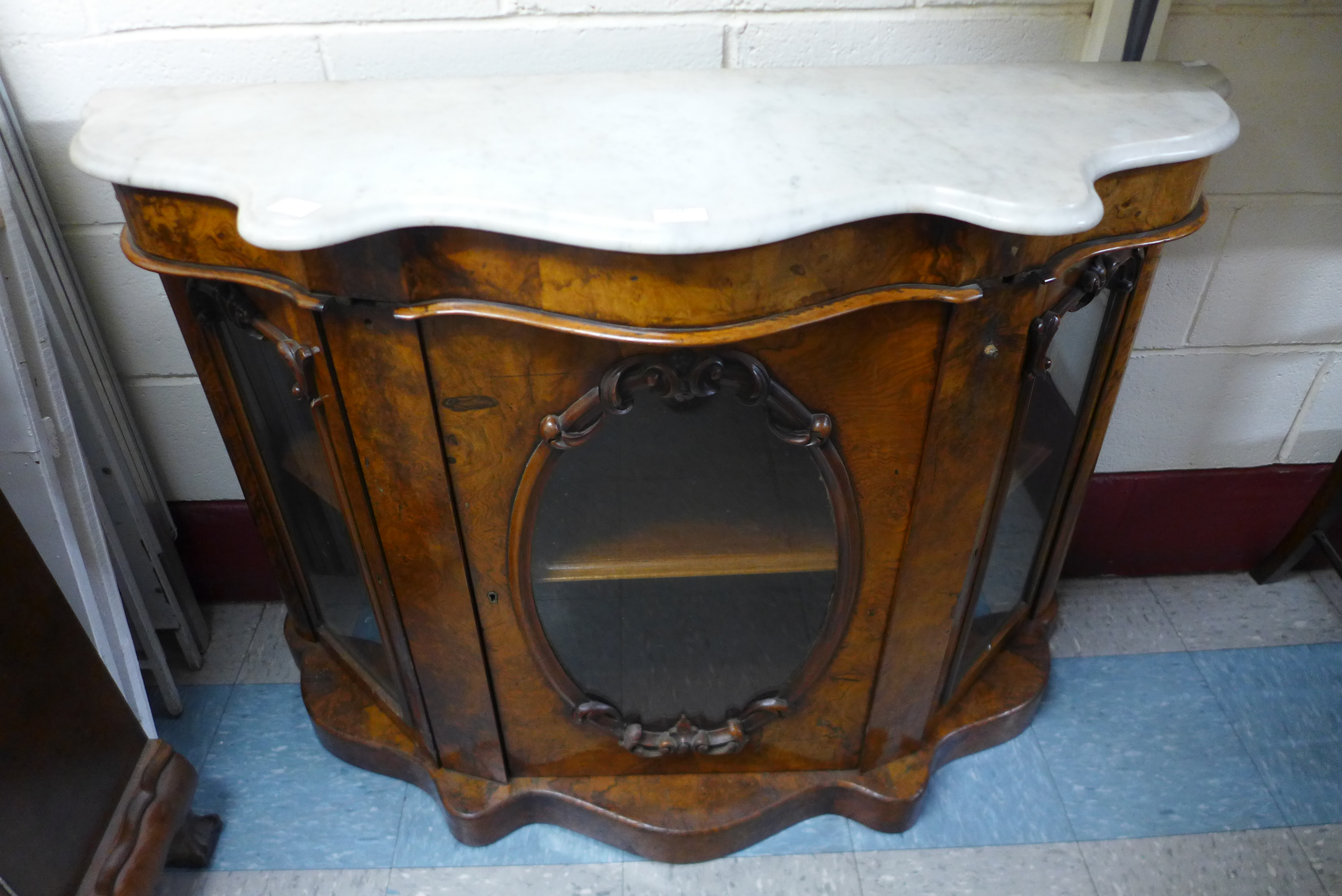 A Victorian walnut and marble topped serpentine credenza, 88cms h, 122cms w, 41cms d.