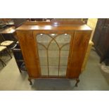 A walnut single door display cabinet