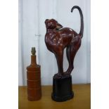 A teak table lamp and a metal figure of a cat