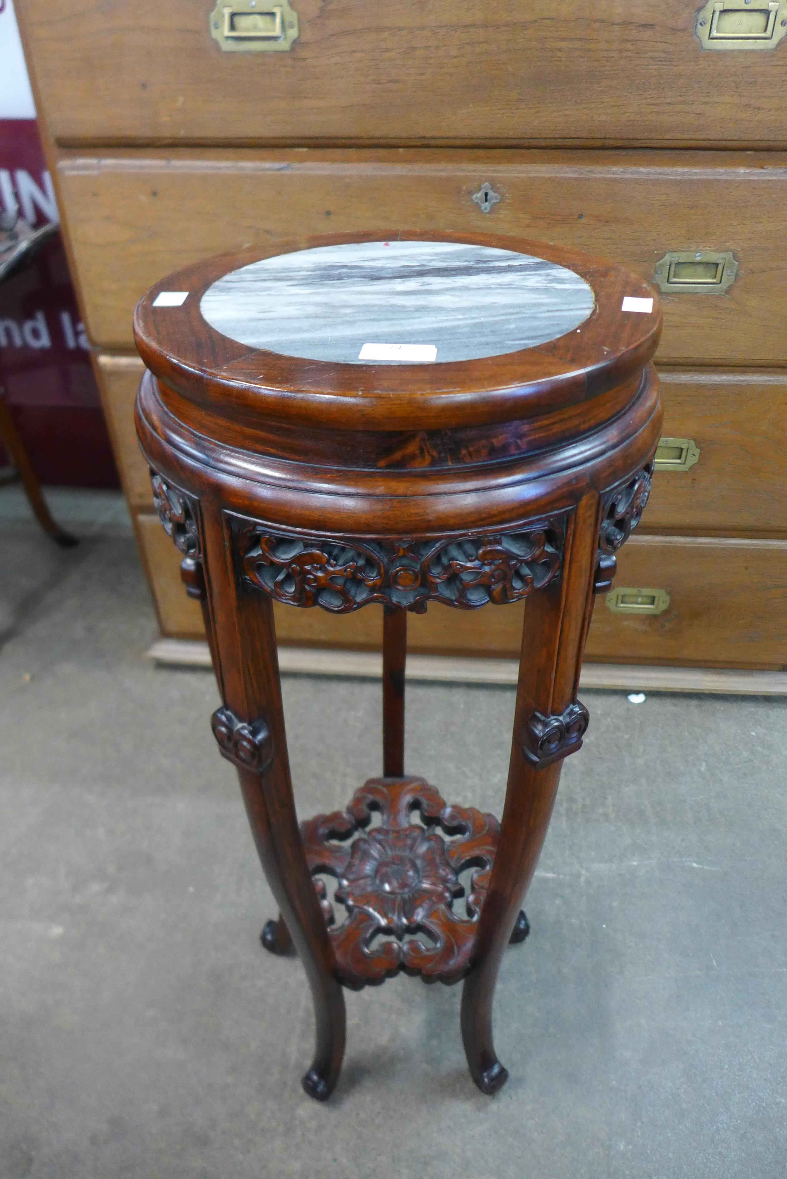 A Chinese carved hardwood and marble topped jardiniere stand, 82cms h, 32cms dia.