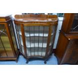 A mahogany serpentine single door display cabinet