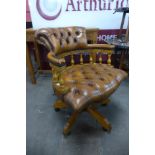 A mahogany and leather revolving desk chair