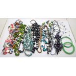 A collection of glass bead jewellery and two jade bangles