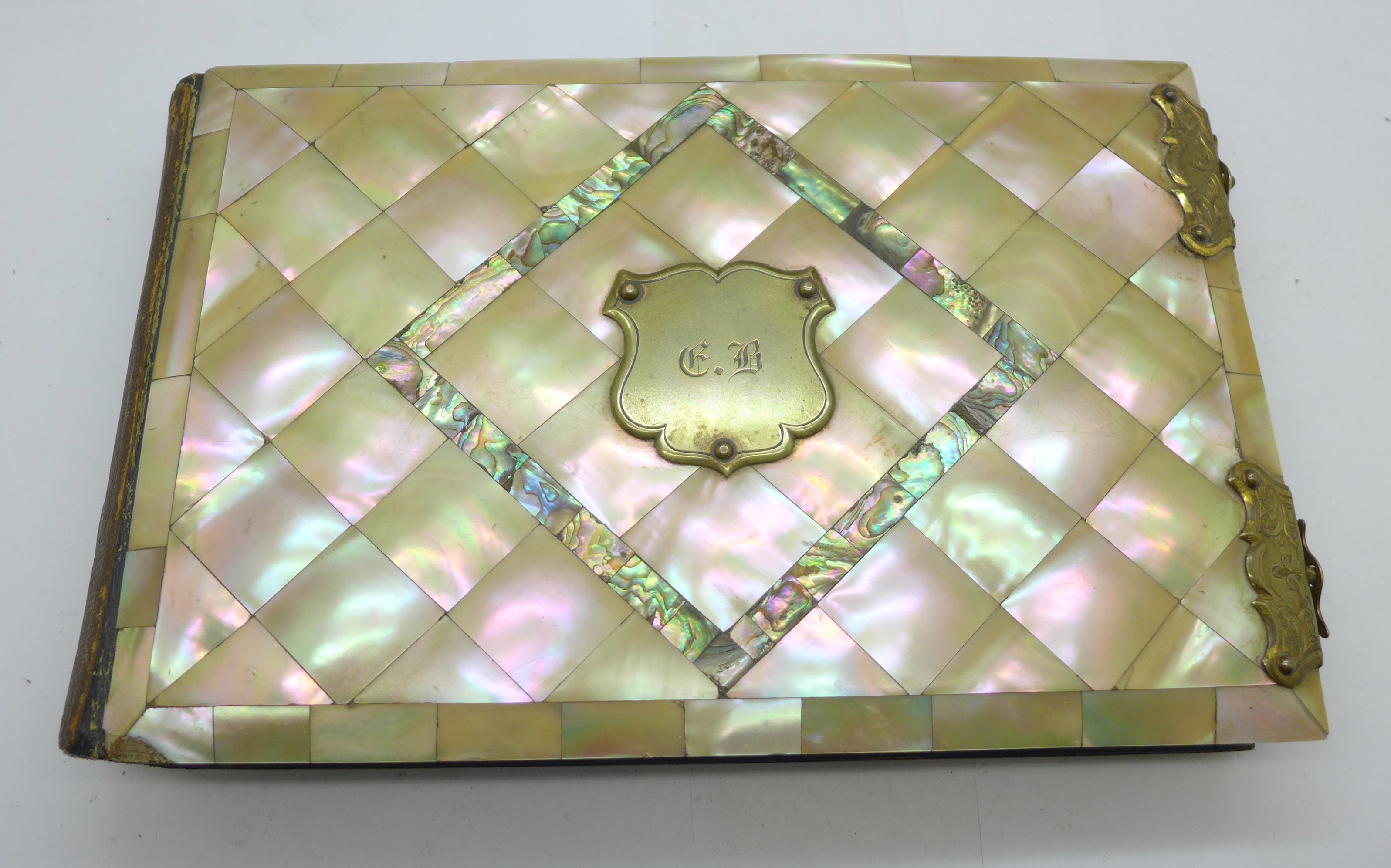 A late Victorian photograph album with mother of pearl and abalone cover, 23.5cm x 15cm, (some