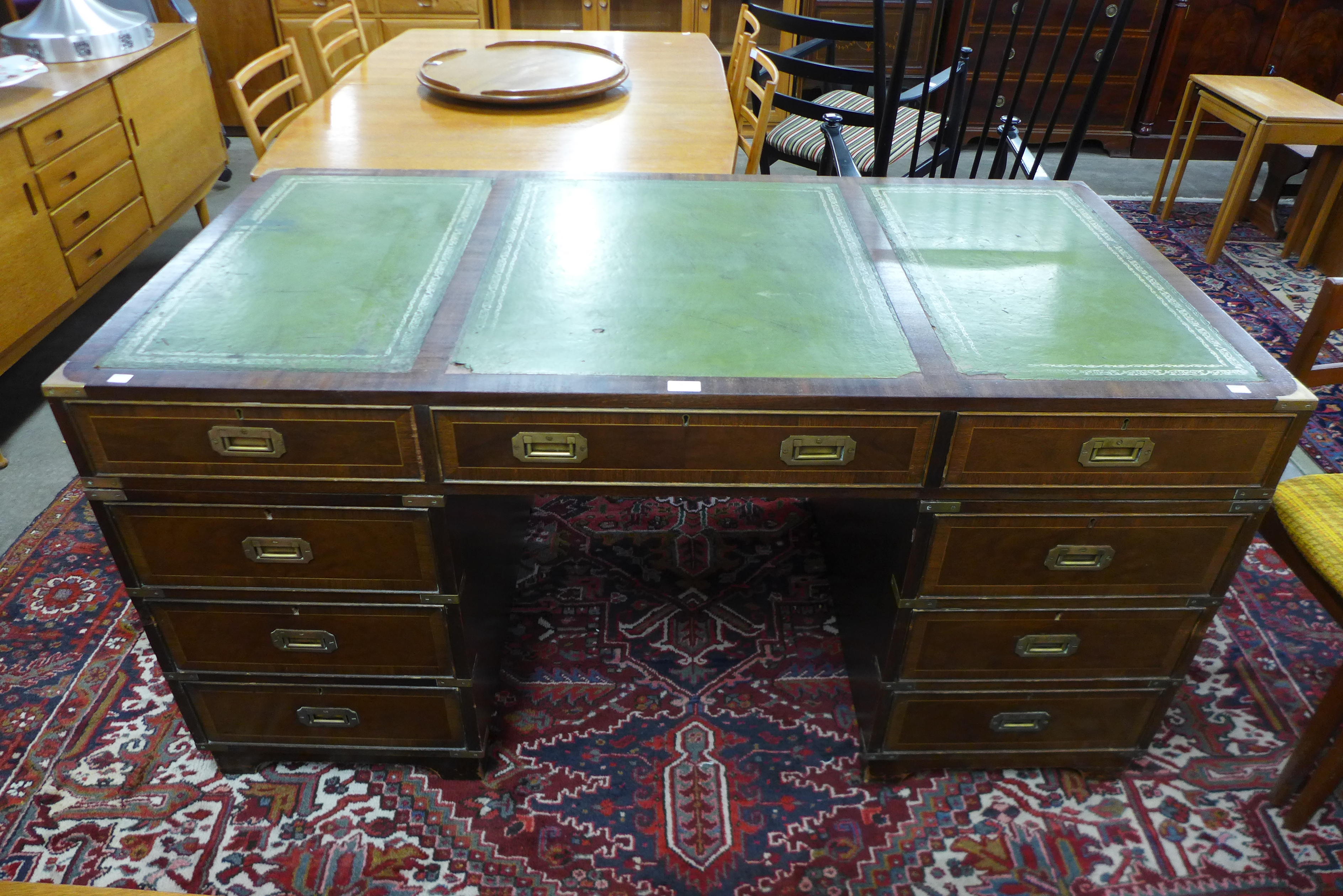 A campaign style mahogany, brass mounted and green leather topped desk