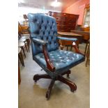 A mahogany and blue buttoned leather revolving desk chair