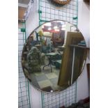 A large circular bevelled edge mirror