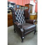 A brown leather Chesterfield wingback armchair