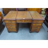 A mahogany and brown leather topped breakfront library desk