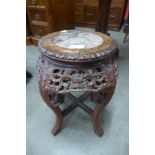 A small Chinese carved hardwood and marble topped jardiniere stand