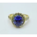 A silver gilt, blue stone and CZ ring in a halo setting, Q