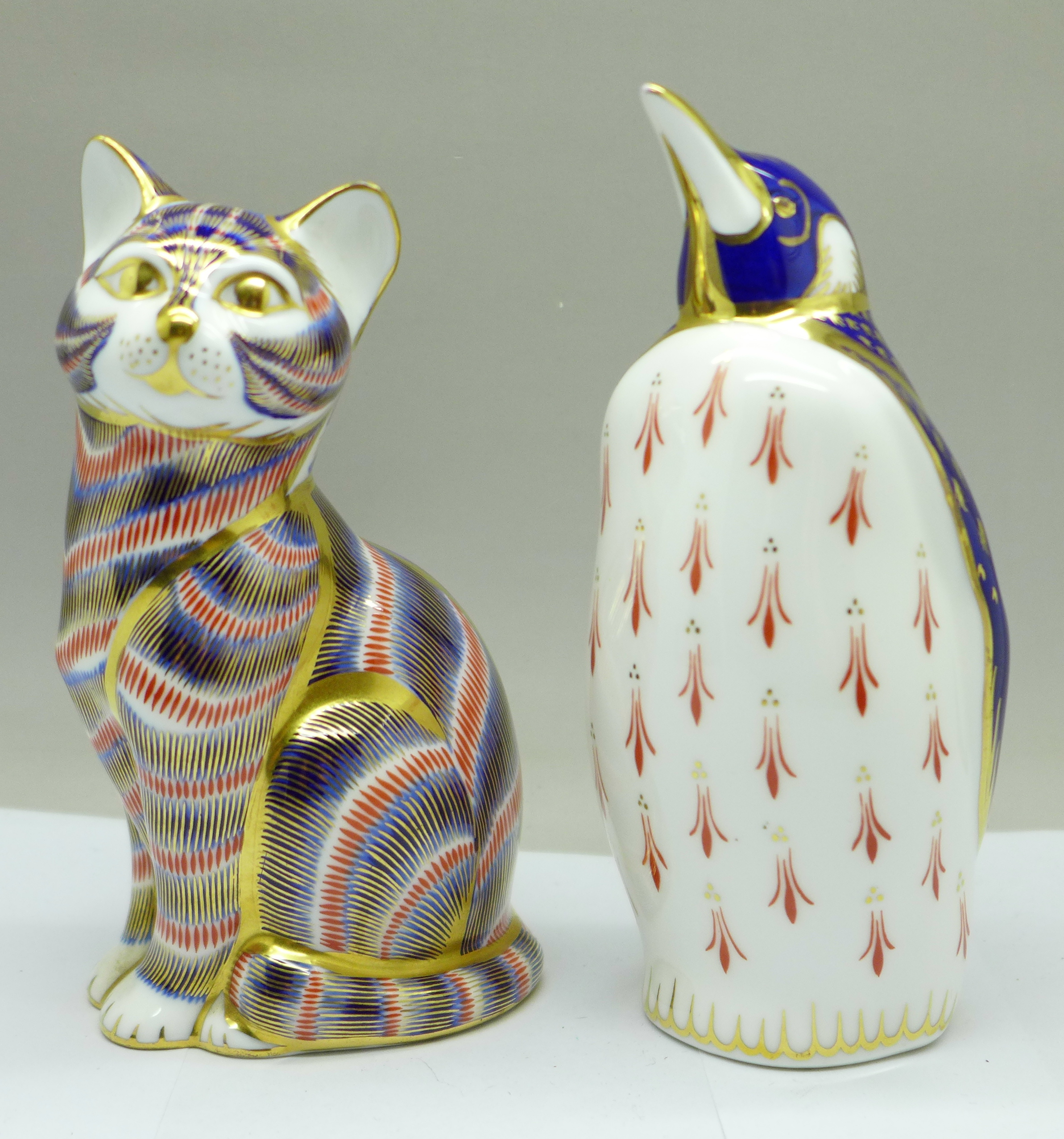 Two Royal Crown Derby paperweights, penguin and cat with silver stopper