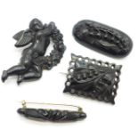 Four brooches;- two jet brooches, a cherub brooch and a carved rectangular shaped brooch, oval
