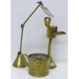 A brass articulated freestanding toasting fork on a weighted base, a brass oil burning lamp and a