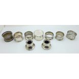 Seven silver napkin rings and a pair of silver inkwells, a/f, (weight of napkin rings 103g)