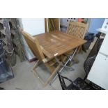 A teak folding garden table and two chairs