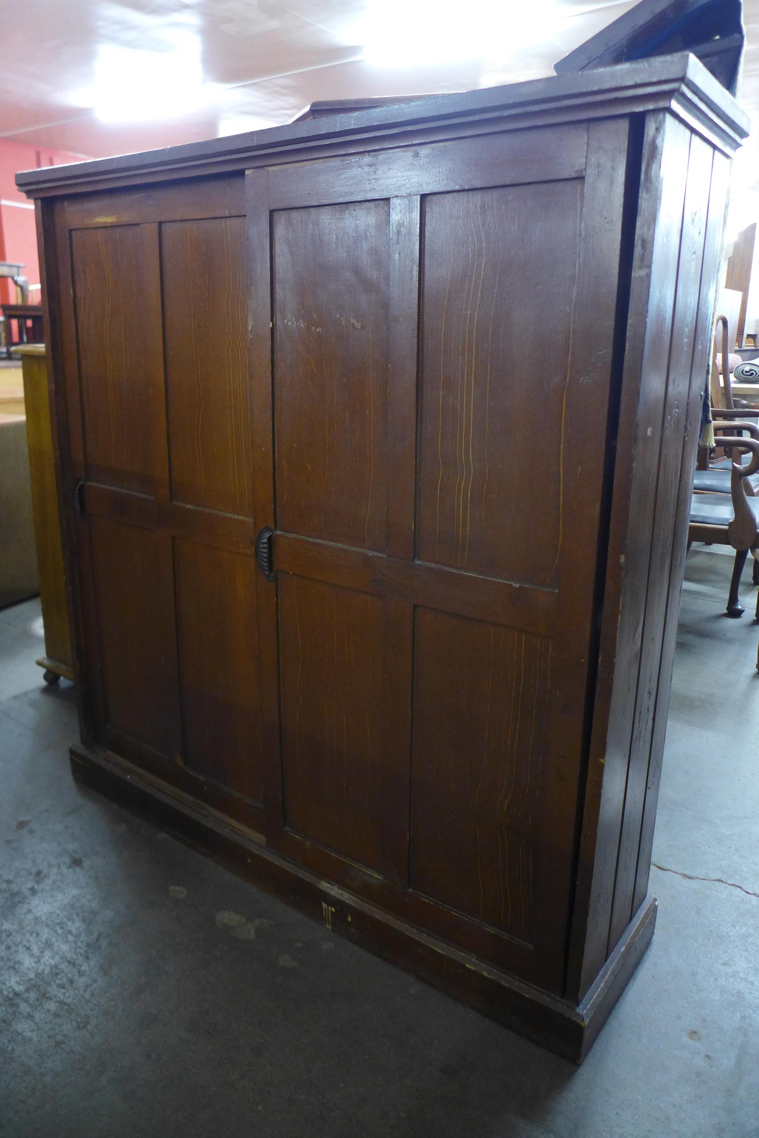 A Victorian pine sliding two door cupboard