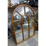 A hardwood framed cathedral style mirror