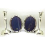 A pair of silver candlesticks and a pair of silver photograph frames, frames 118mm x 154mm