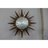 A Metamec sunburst teak wall clock