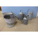 Three galvanised watering cans and two buckets