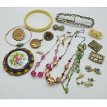 A collection of vintage jewellery including a porcelain brooch, three necklaces and two buckles