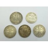 Three Indian one rupee silver coins, 1888, 1892 and 1920, a German 1908 Drei mark coin and a South