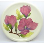 A Moorcroft Magnolia pattern plate, tube lined decoration on a cream ground, 26cm diameter, boxed