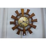 A Eurastyle teak and brass sunburst wall clock