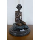 A French style bronze figure of a seated female nude, on black marble socle