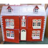 A wooden dolls house with some furniture