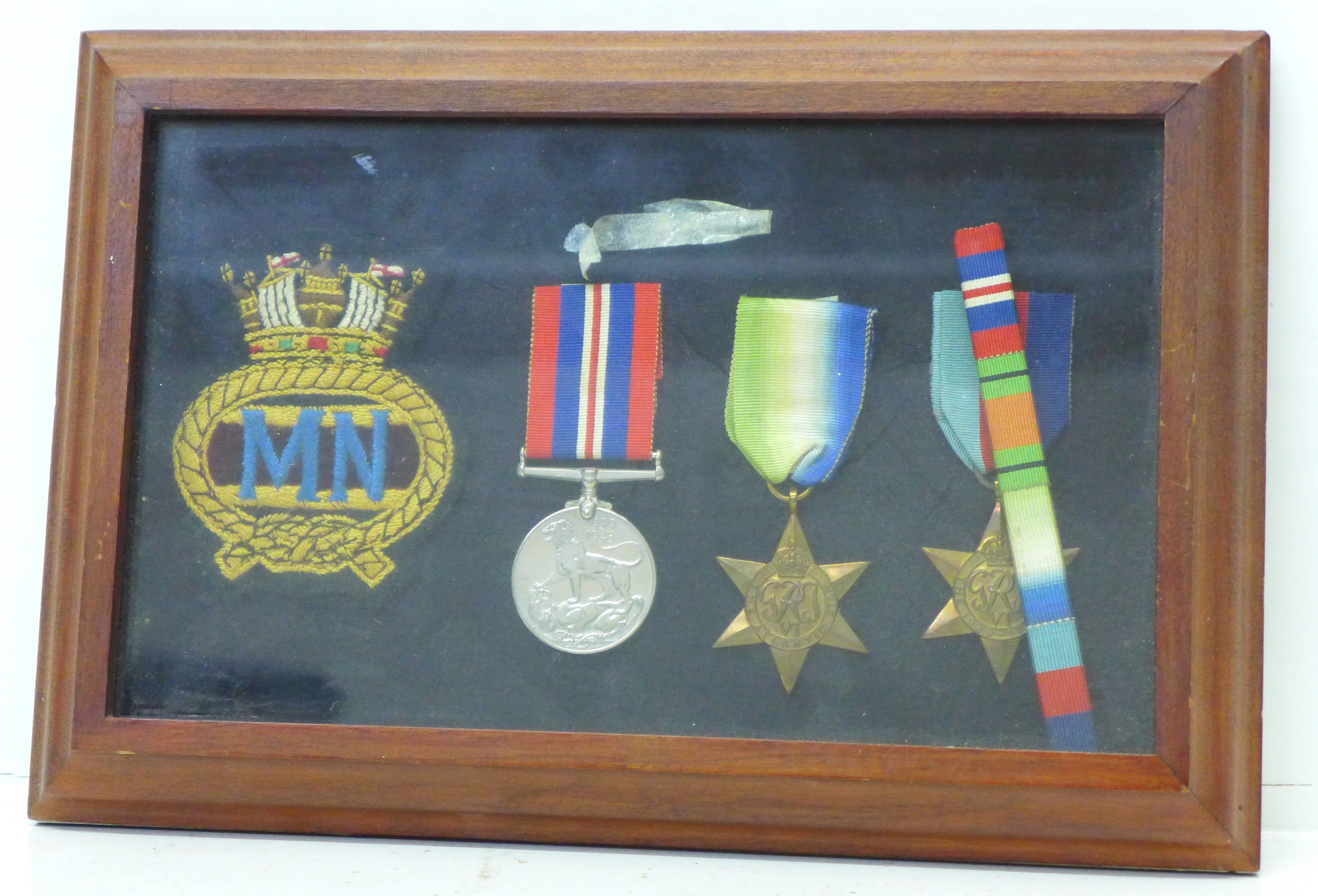 A set of mounted WWII medals with Atlantic and 1939-1945 Star and Merchant Navy cloth badge