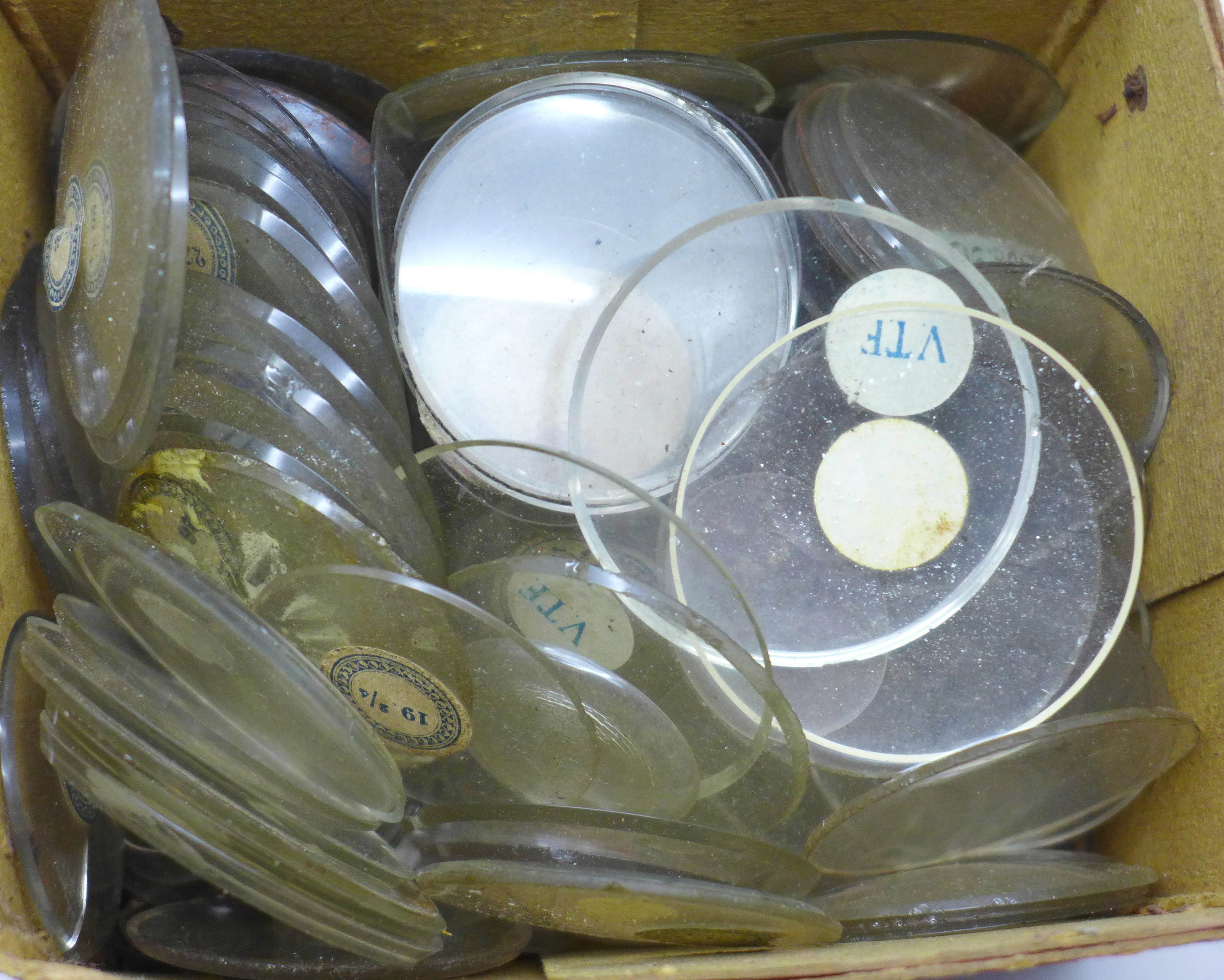 A box of pocket and wristwatch glasses, most with size labels