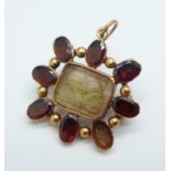 A rolled gold and garnet mourning pendant/brooch, lacking one stone