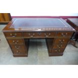 A mahogany and red leather topped pedestal desk