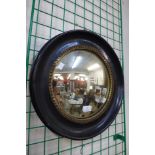 A Victorian ebonised and parcel gilt convex mirror