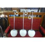 A set of three chrome and glass pendant ceiling lights