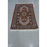 An eastern hand made red ground rug