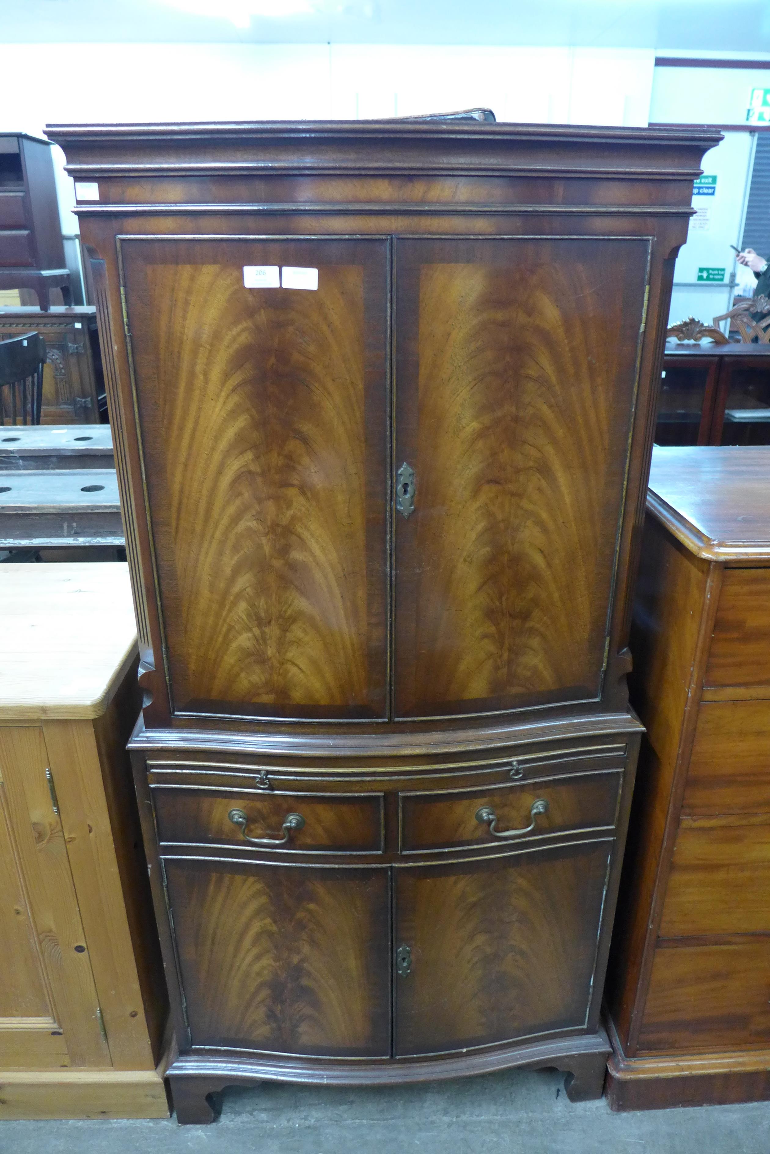 A Bevan Funnell Reprodux mahogany serpentine cocktail cabinet